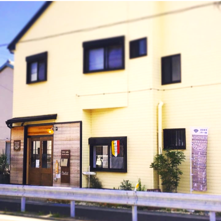 黄色いたてものと　入り口の木目。　木目調にデザインされたのぼり旗には「Wifi」があることをPRするFreeWi－Fiマークもポイントです。